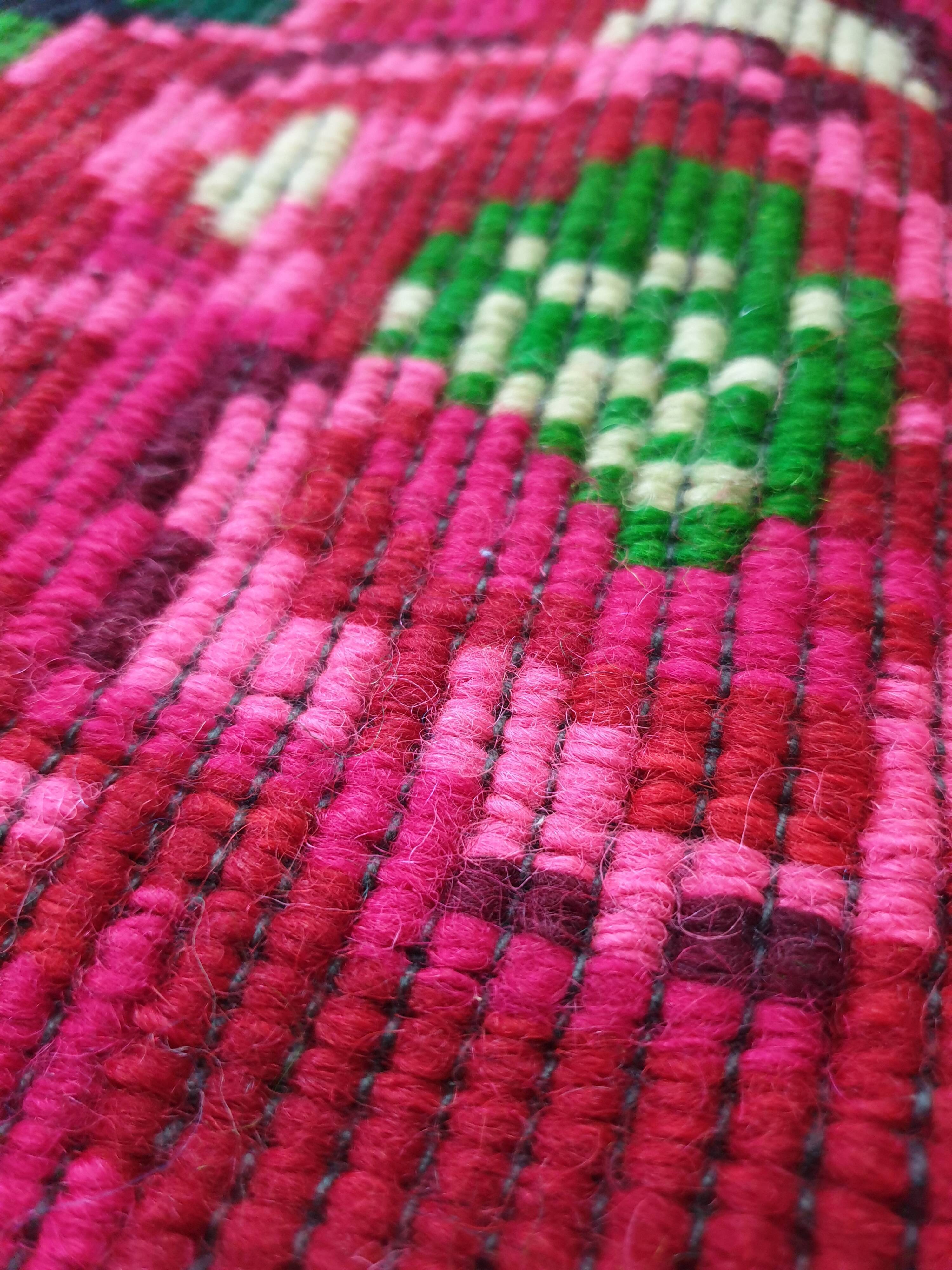 Handwoven floral wool rug, black background with pink roses