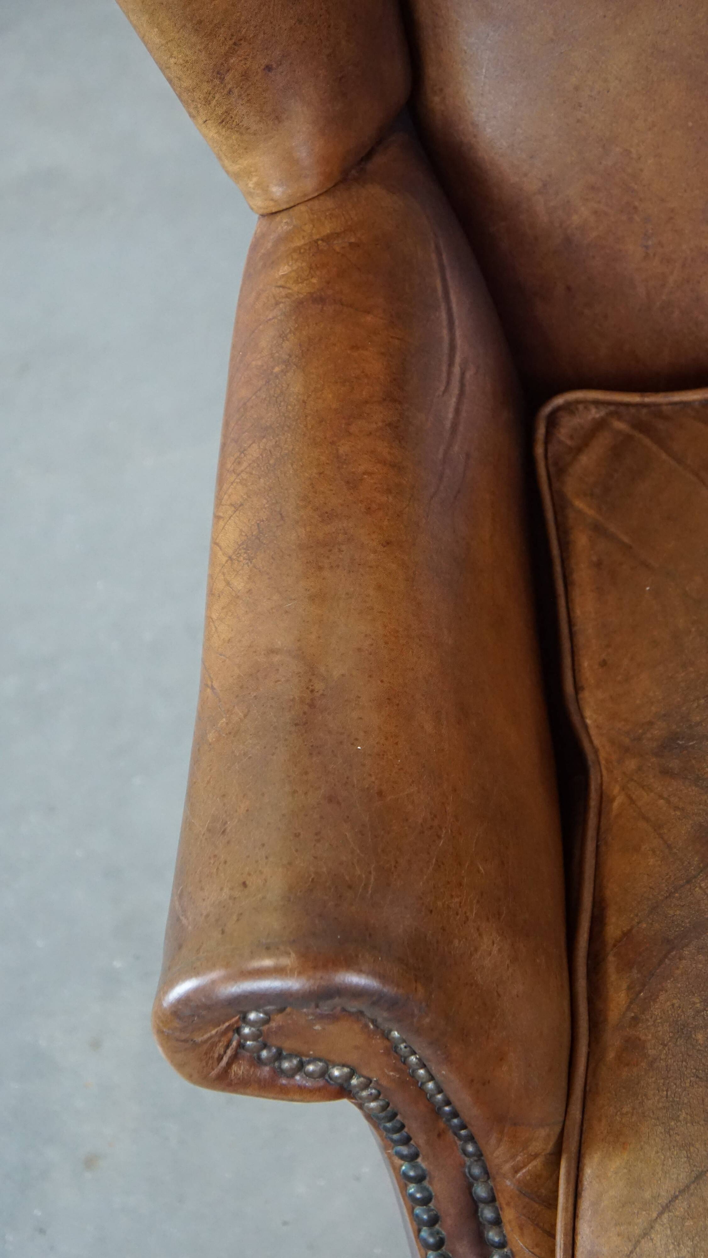 Charming sheep leather wingback armchair with a beautiful patina and excellent seating comfort