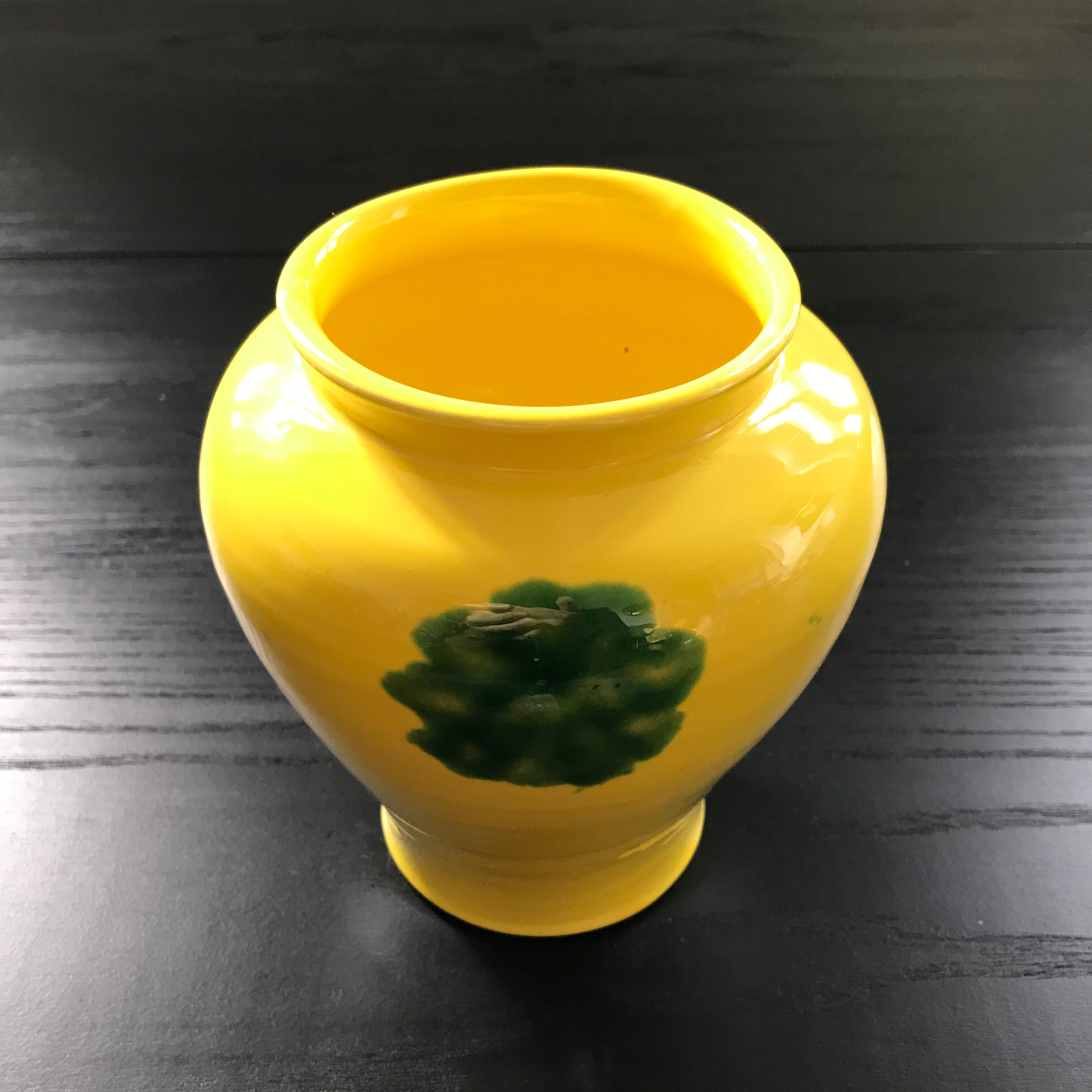 Yellow vase with green spots.