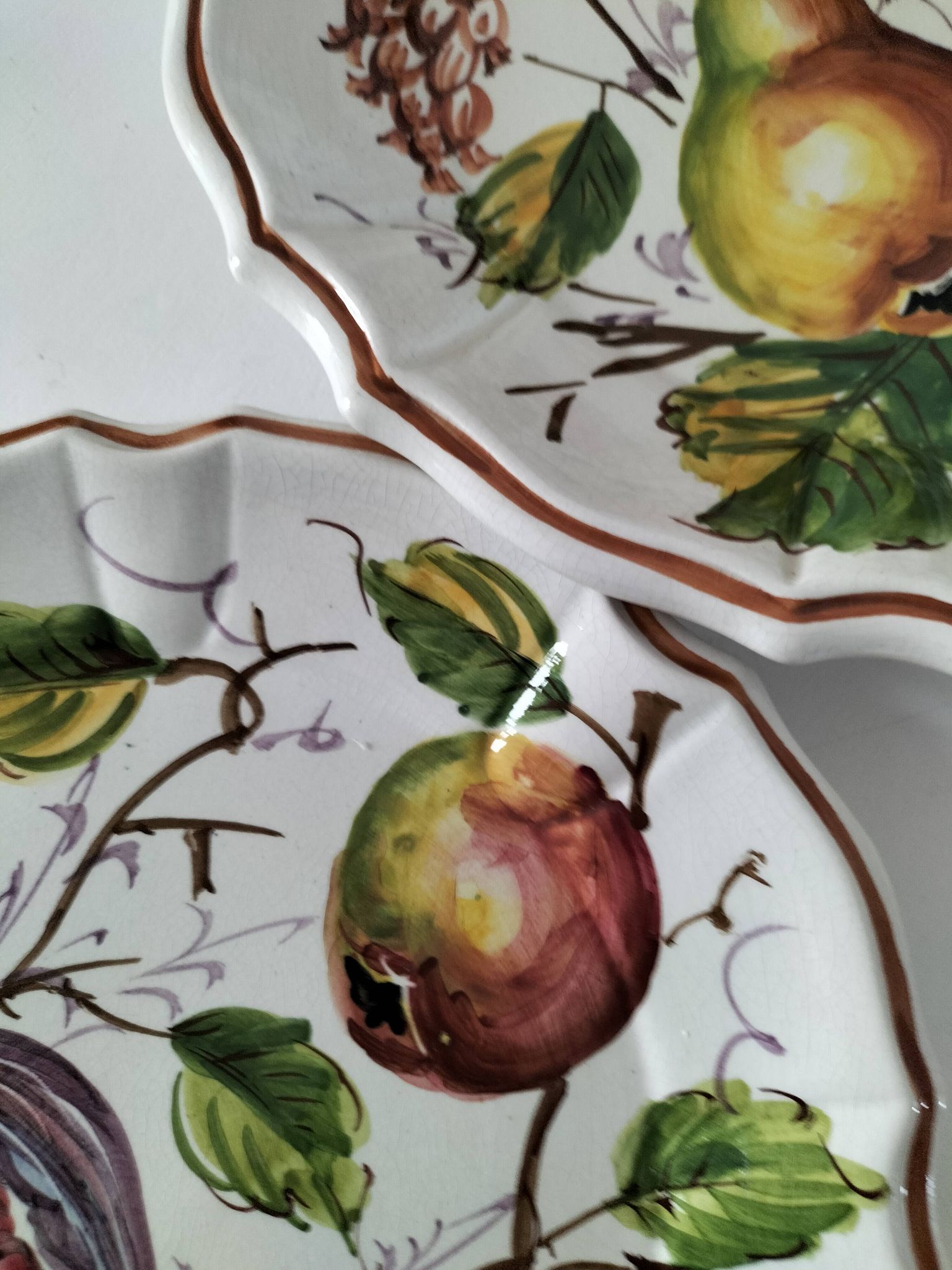 Set of three earthenware plates from Bassano, hand-painted with fruit and flower designs.