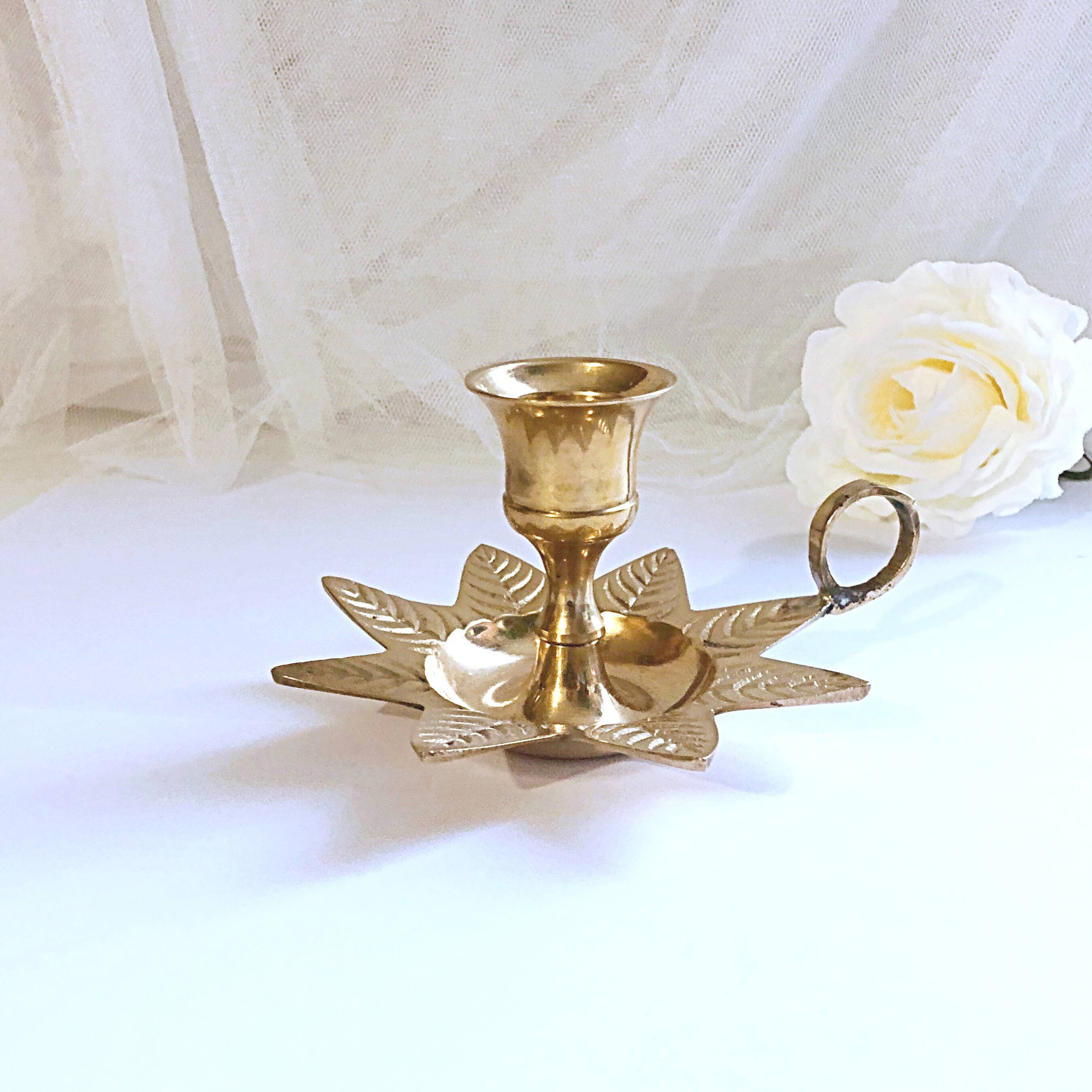 Golden brass hand candle holder decorated with leaves