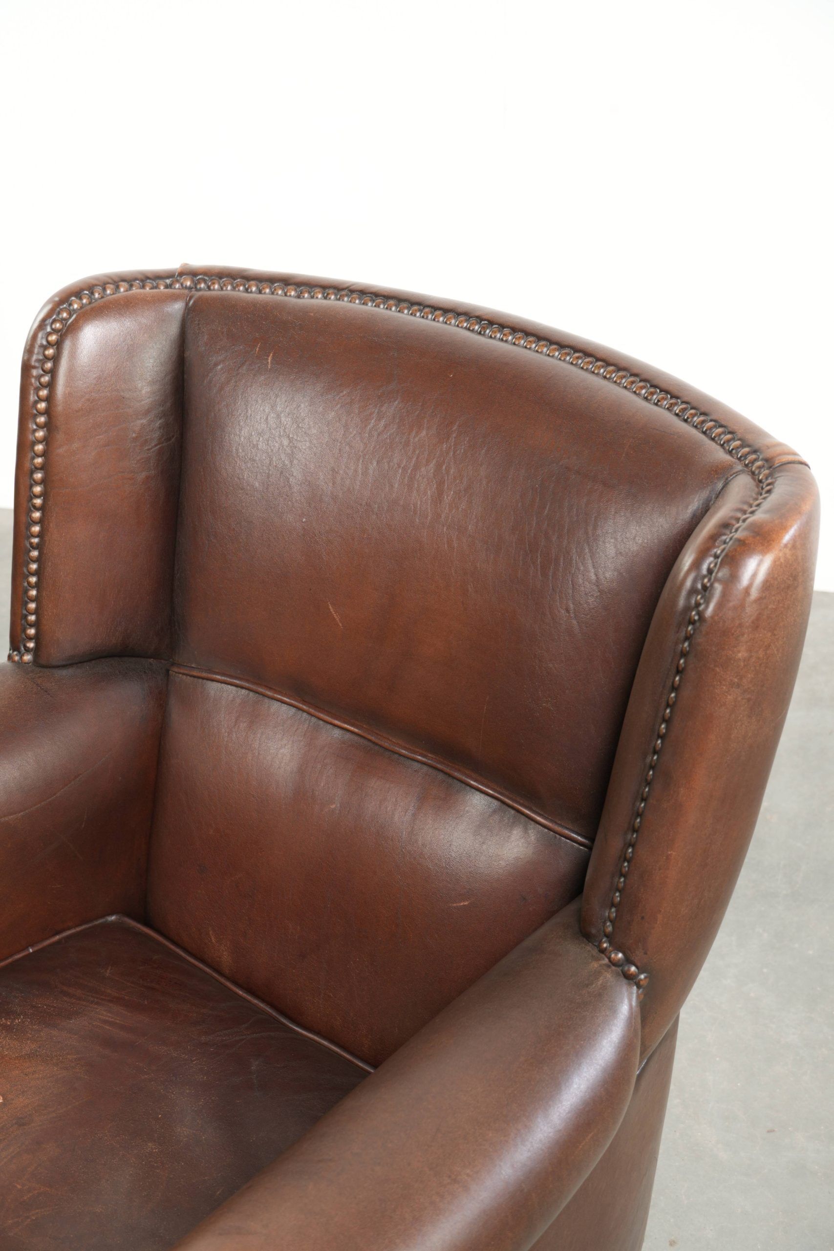 Subtle sheepskin wingback armchair with a deep cognac colour