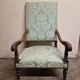 Antique Louis XIV style armchair in moulded wood and damask-style fabric.