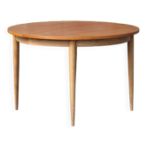 Round wooden dining table with central extensions