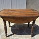 Round dining table with a drop-leaf top in solid walnut, late 19th century.