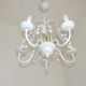 Chandelier vintage en métal blanc à 5 lumières avec des fleurs de glycine roses.