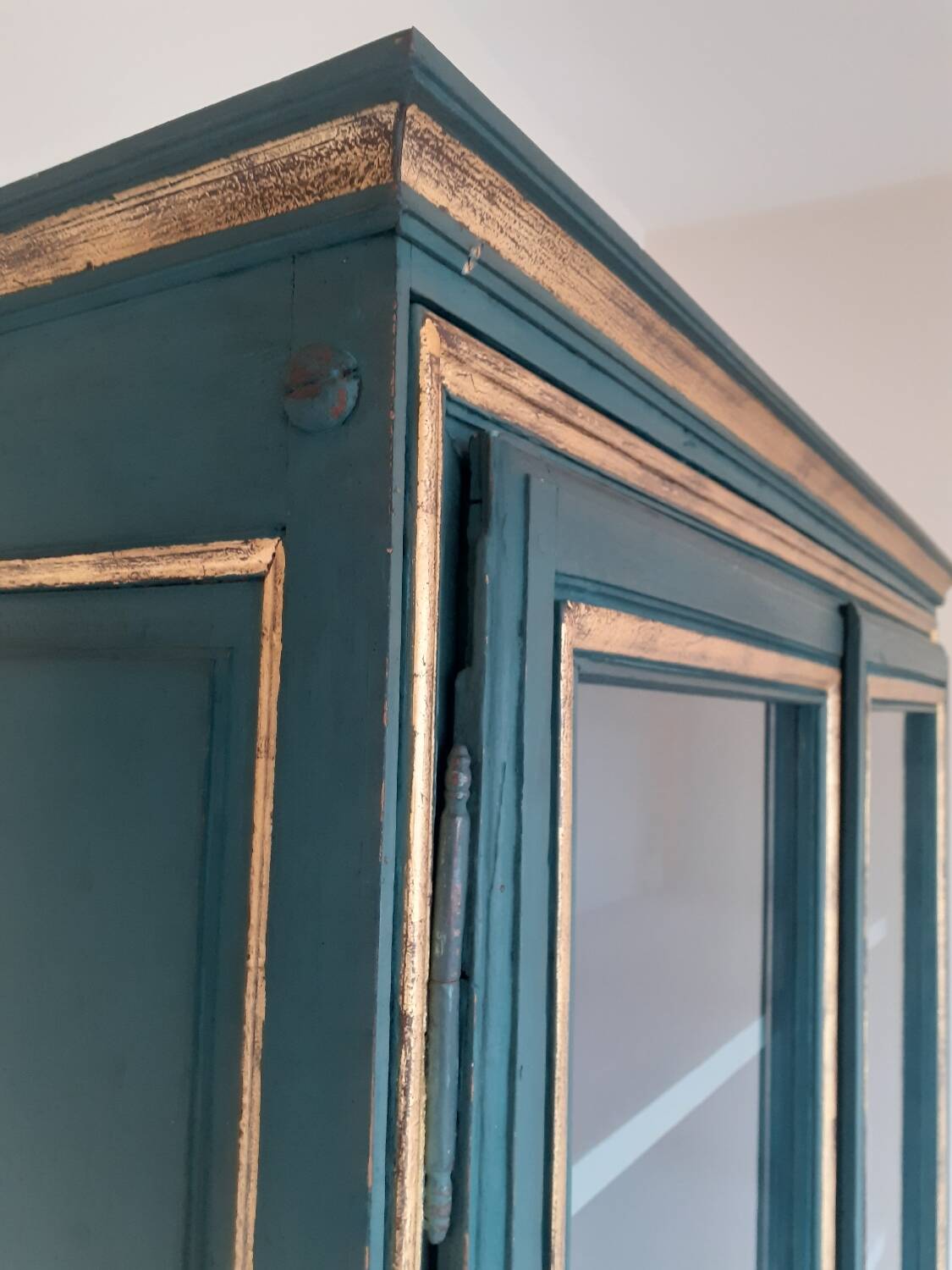 Glass-fronted cabinet in weathered green wood