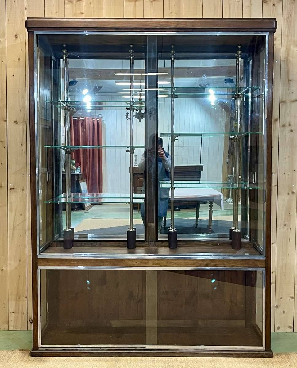 Early 20th-century shop display cabinet in oak with sliding doors.