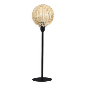 Table lamp with a gold-trimmed globe and a black base