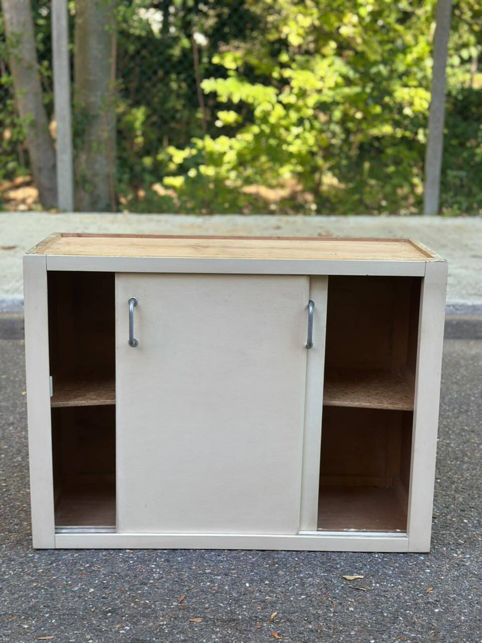 Vintage wall-mounted kitchen cabinet with sliding doors in 1960s retro style.