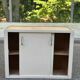Vintage wall-mounted kitchen cabinet with sliding doors in 1960s retro style.