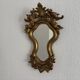 Antique rococo mirror with putti, gilded carved wood and stucco frame, 19th century.