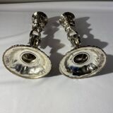 Two silver-plated metal candlesticks decorated with cherubs, 20th century