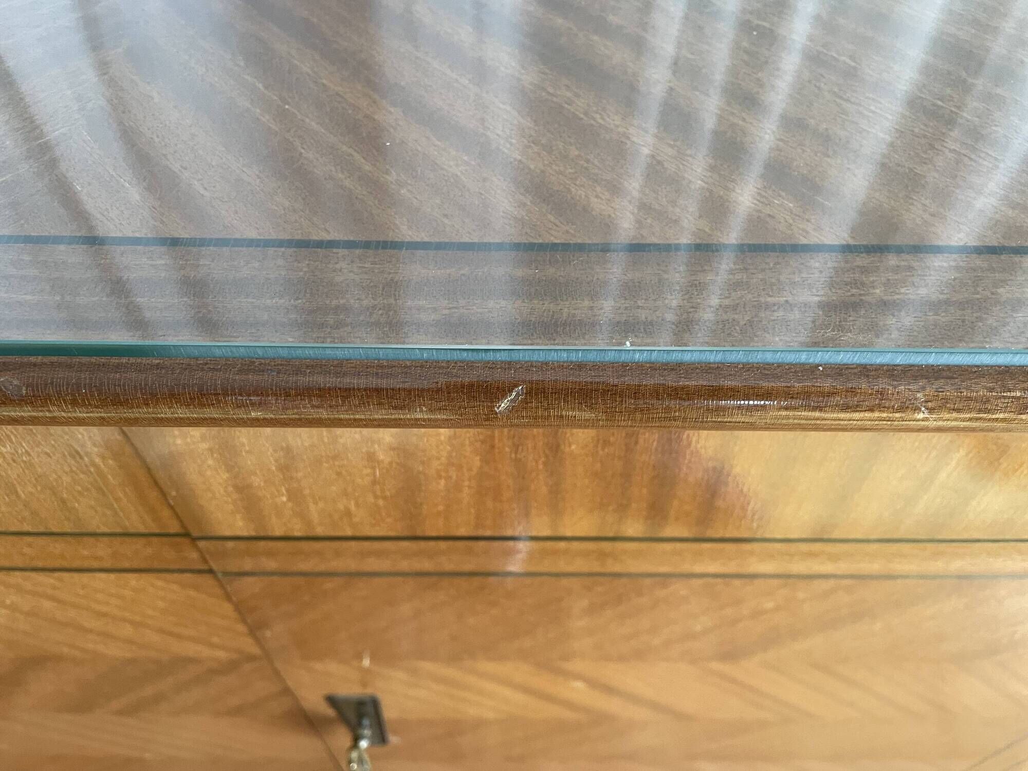Vintage 4-door buffet with wood veneer and glass top.