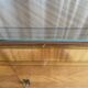 Vintage 4-door buffet with wood veneer and glass top.