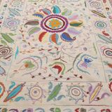 White suzani kilim rug with embroidered multi-colored patterns