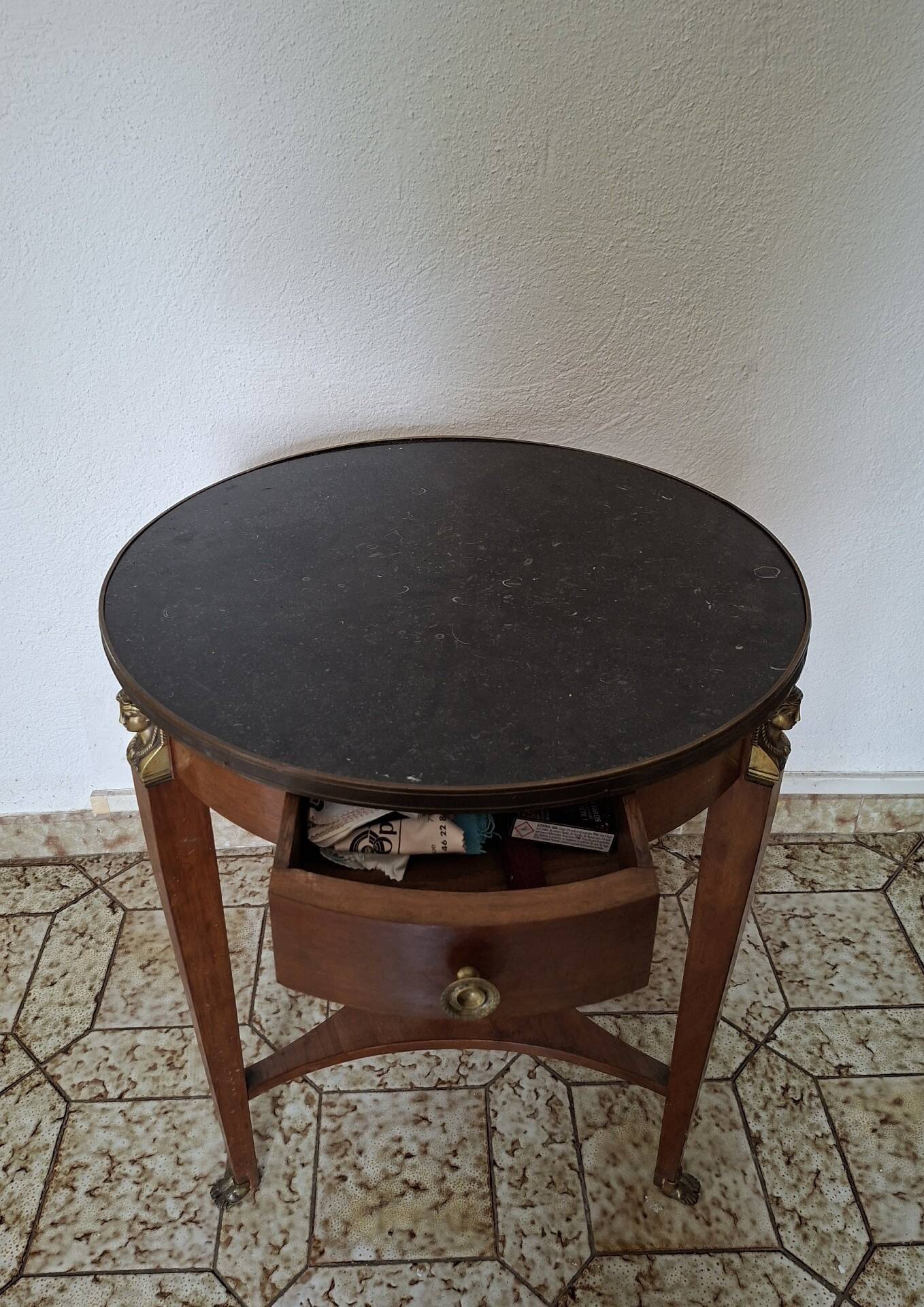 Empire guéridon table in mahogany with a black marble top and gilded bronze.