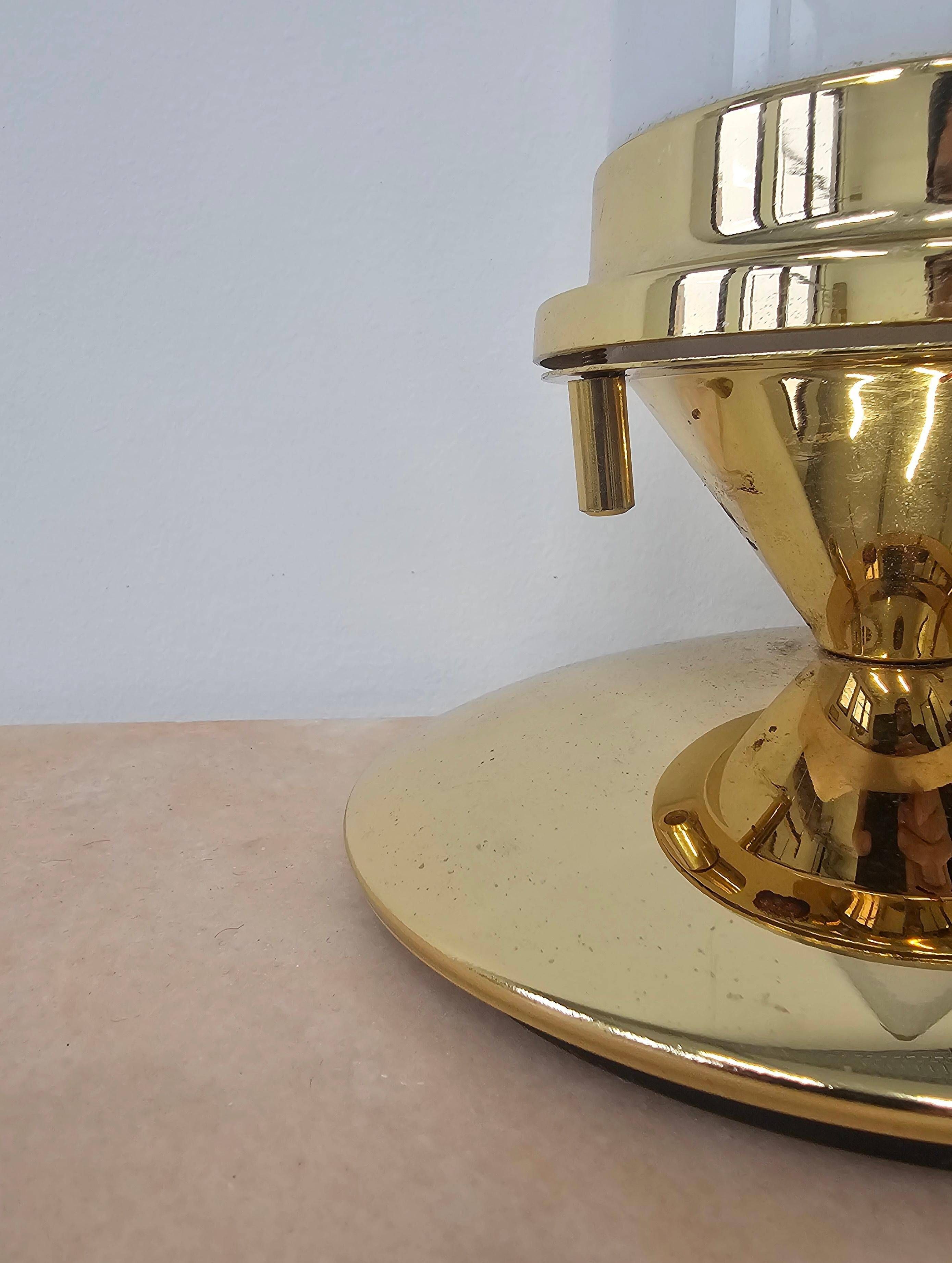 Pair of Hollywood Regency table lamps in brass with glass shades.