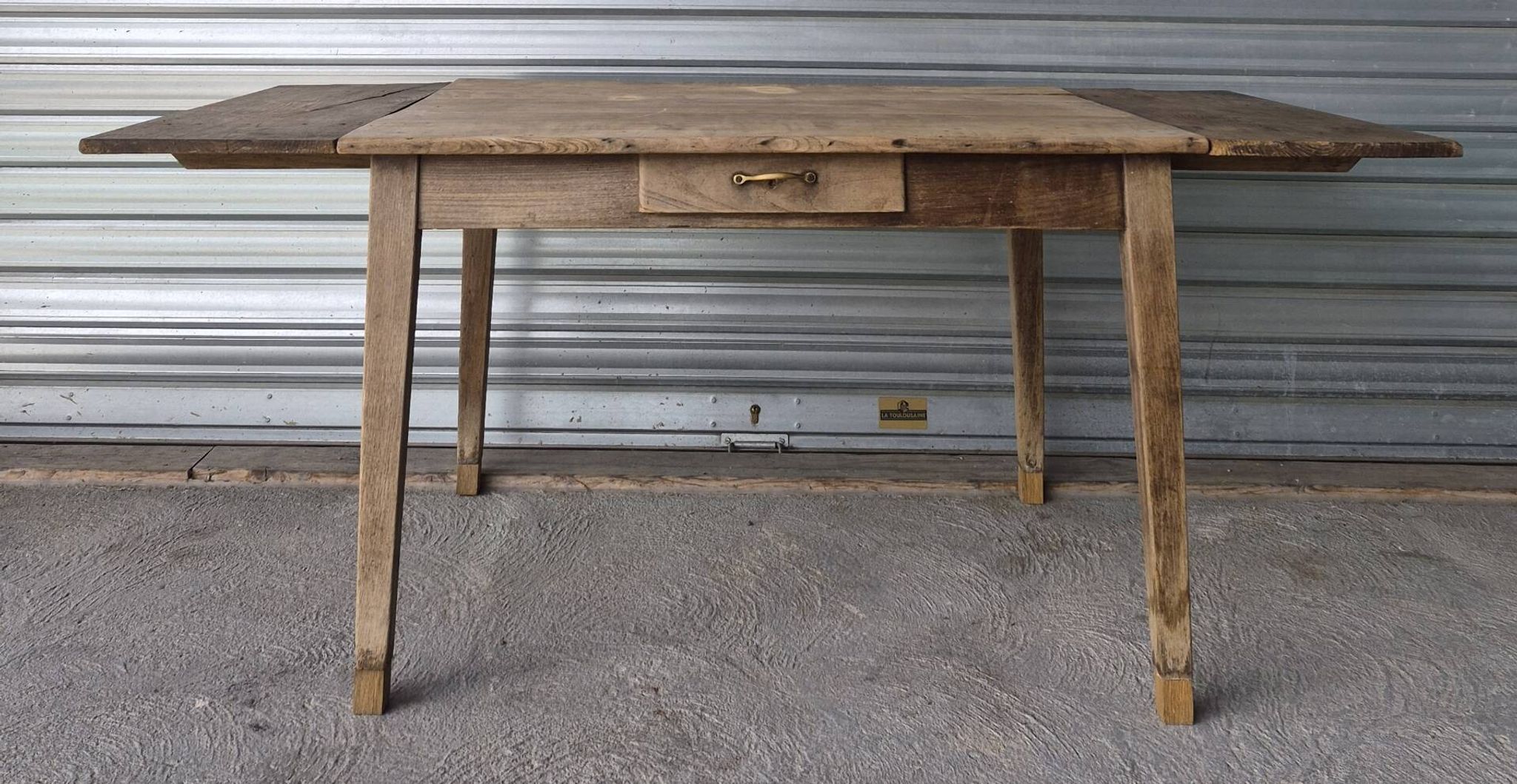 Old farmhouse table with its 2 extensions and raised legs.