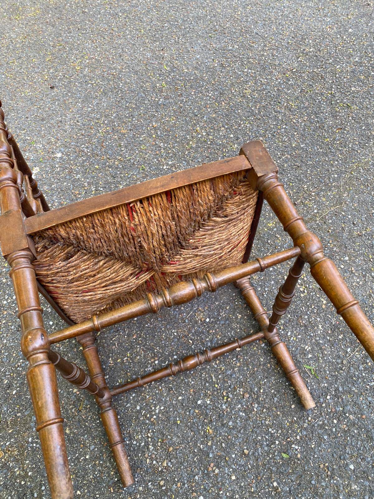 19th-century solid wood corner chair with red and blue rush seating.