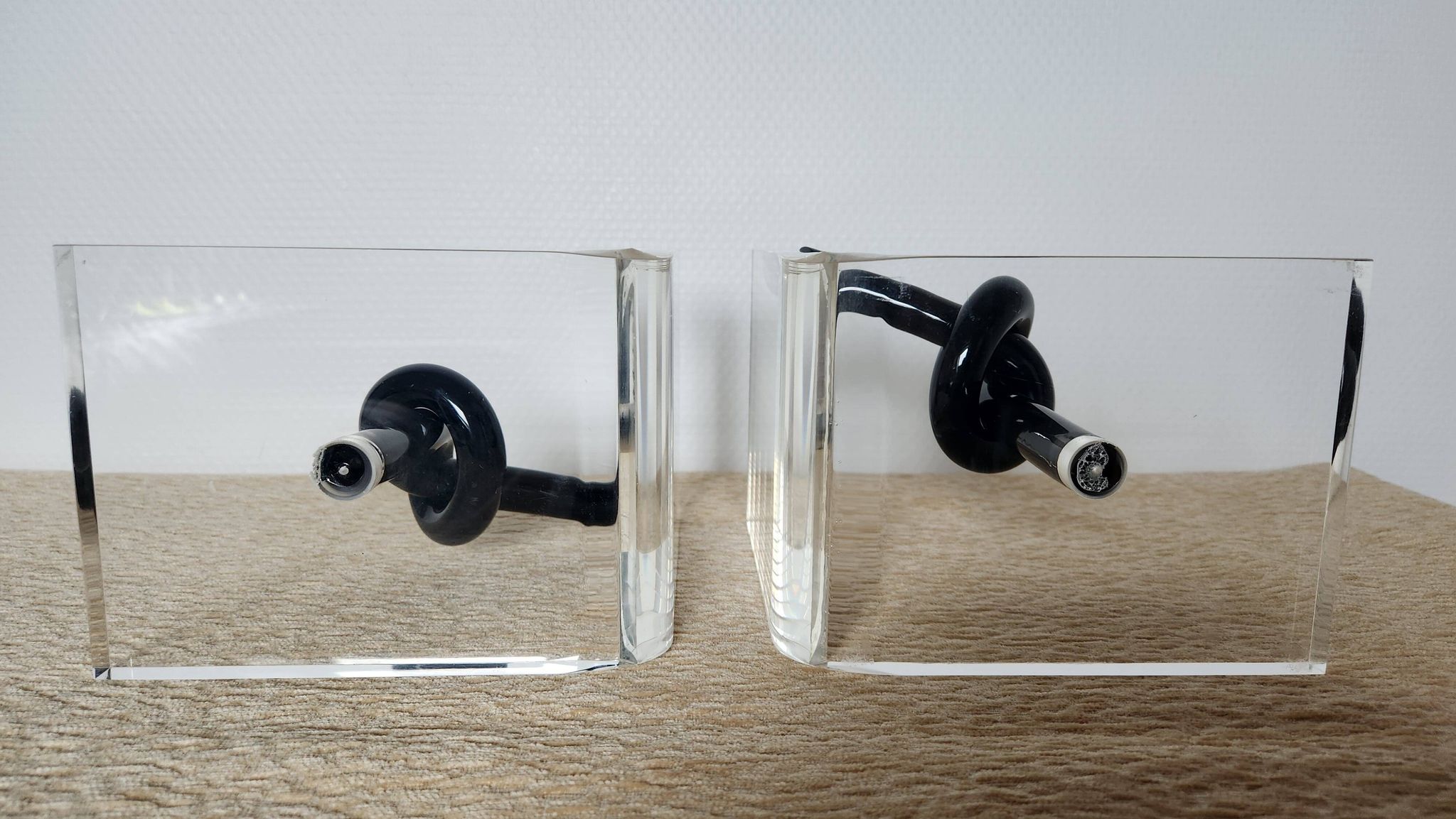 Bookends in plexiglass and knotted black tubes, 1980s design.