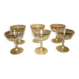 6 old champagne glasses with white arabesque pattern.