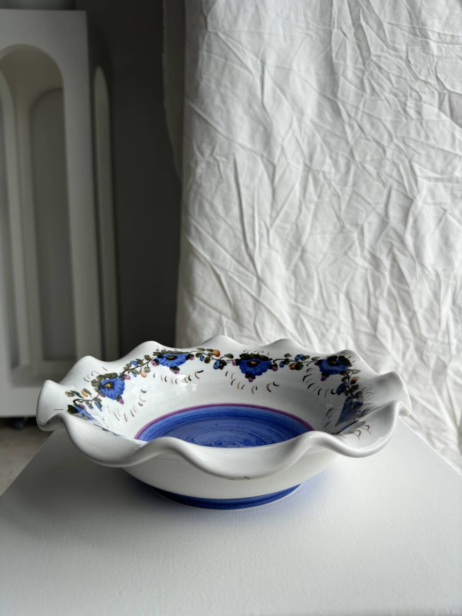 Small hand-painted earthenware salad bowl with garland of blue flowers, mark below