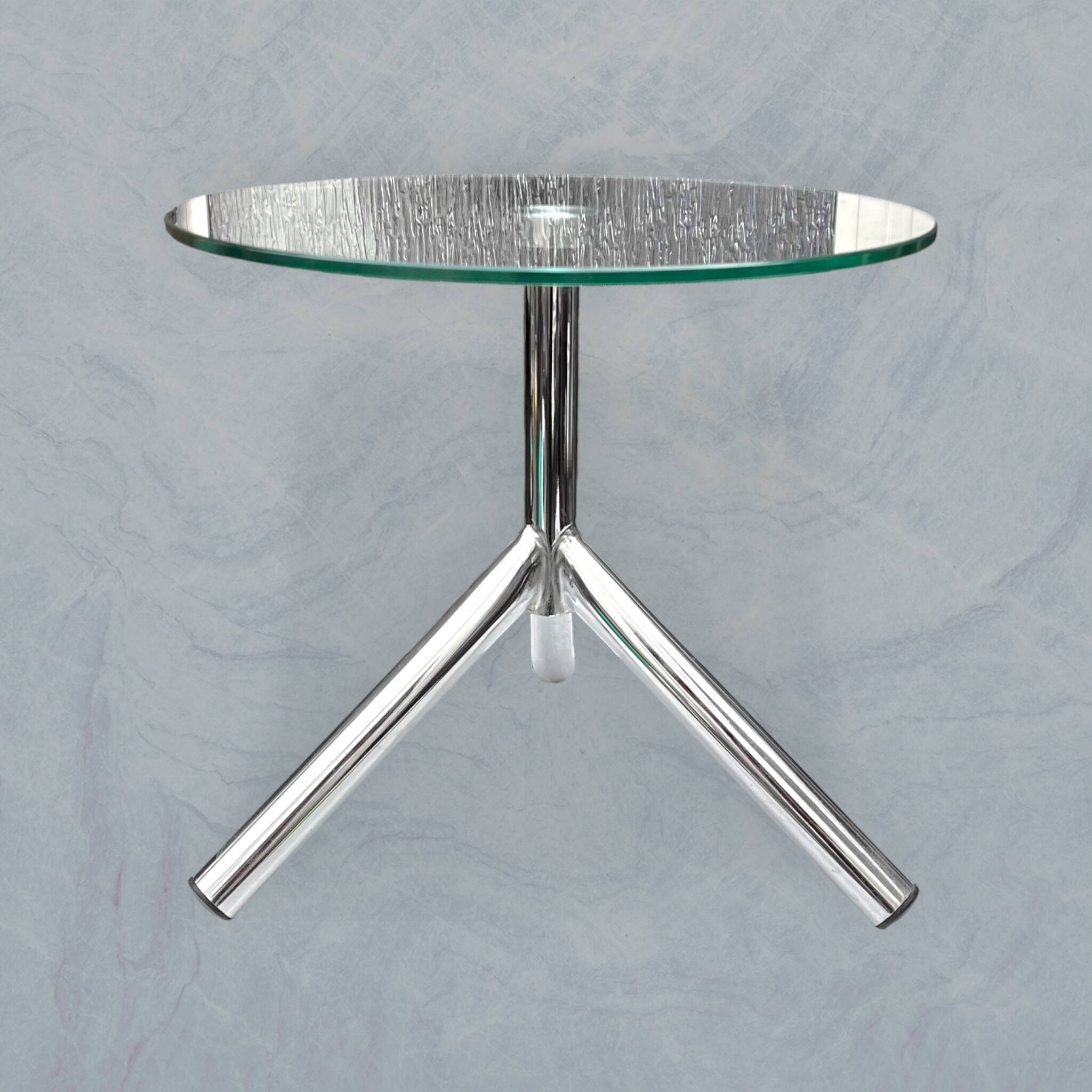 Modernist tripod side table in tempered glass and chrome metal.