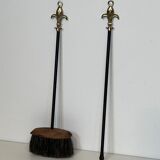 Neoclassical-style fire accessory in black lacquered metal and brass with fleur-de-lis.