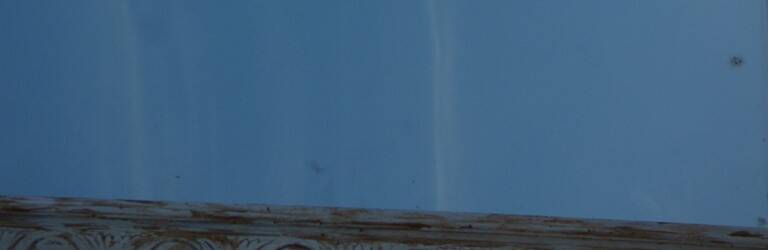 Chic and stylish old mirror with carved wooden frame in limed white and gold