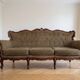 Classic 3-seater sofa in brown fabric and wood.