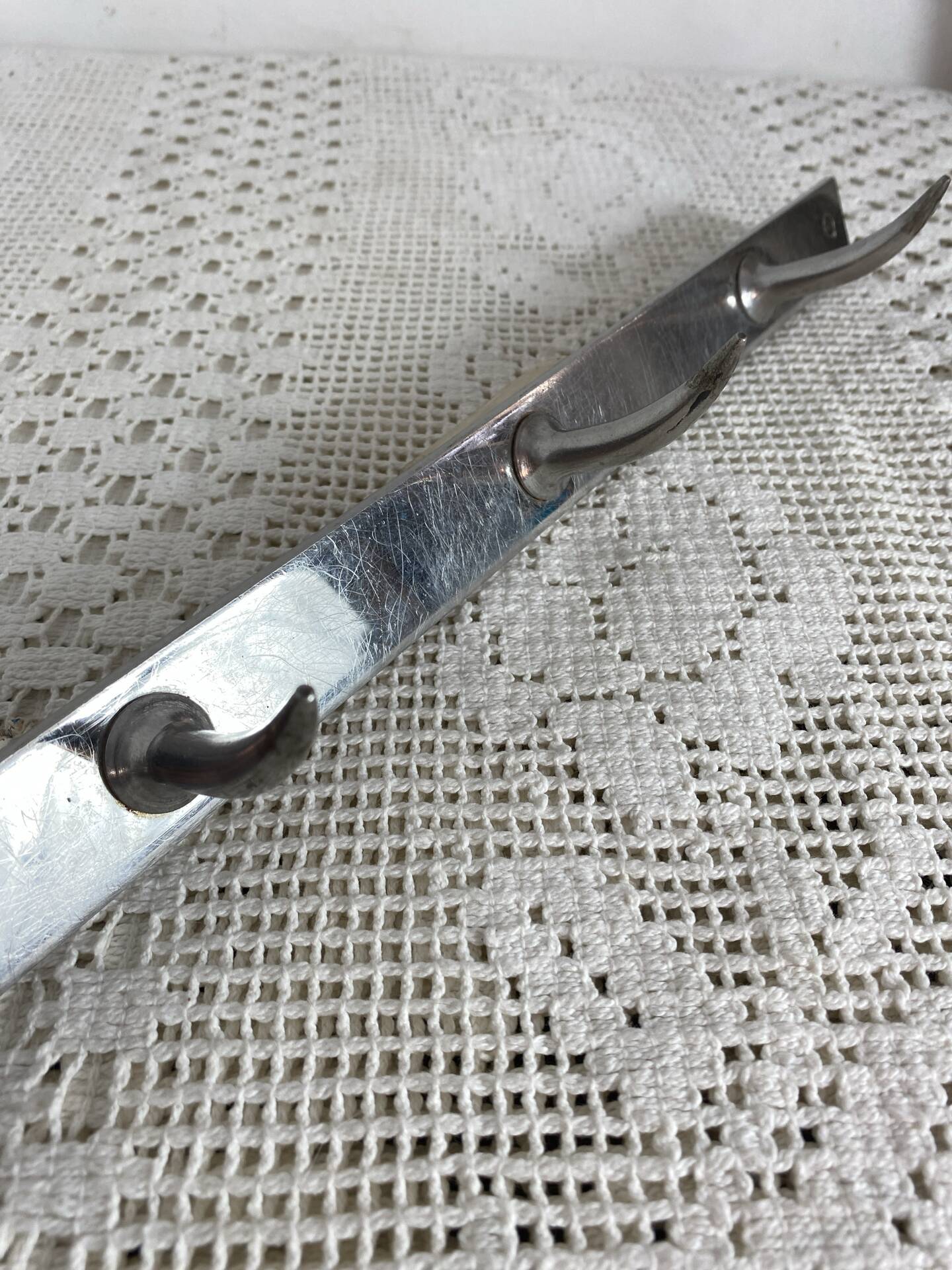 Stainless steel butcher's hook, known as a "wolf tooth bar."