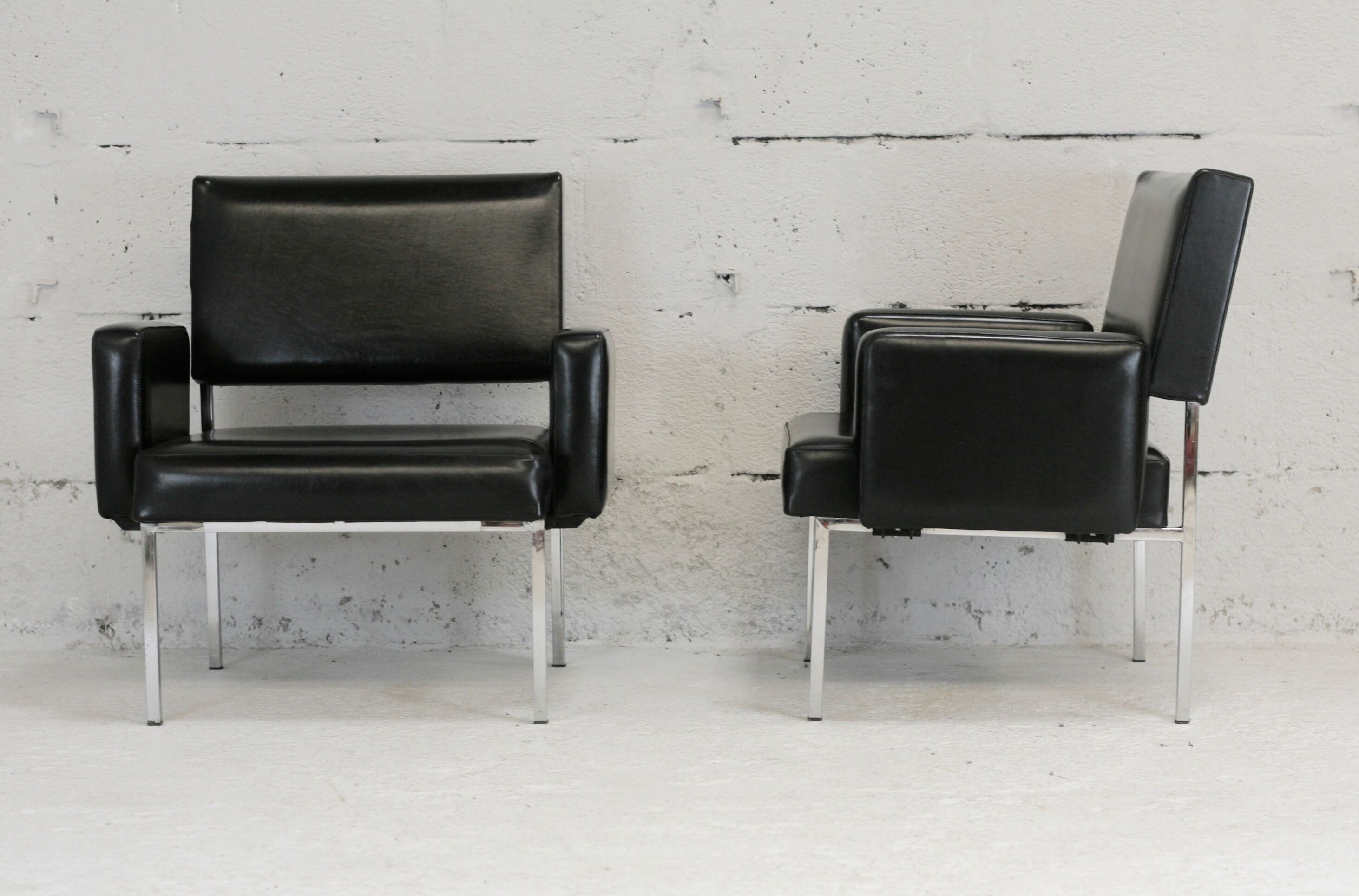 Pair of stainless steel, black leather-like armchairs, France, circa 1970