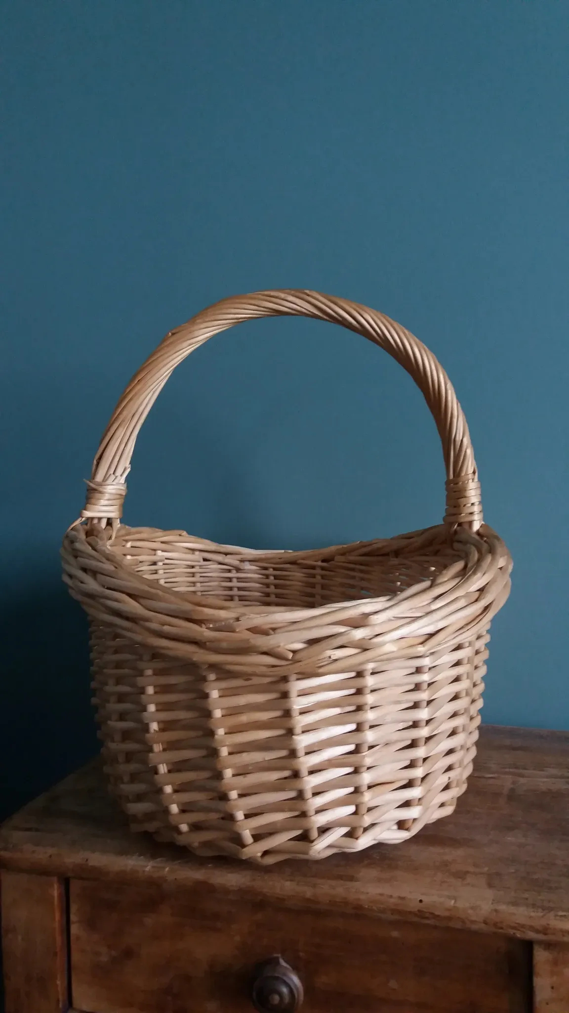 Handcrafted wicker basket with a handle.