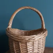 Handcrafted wicker basket with a handle.