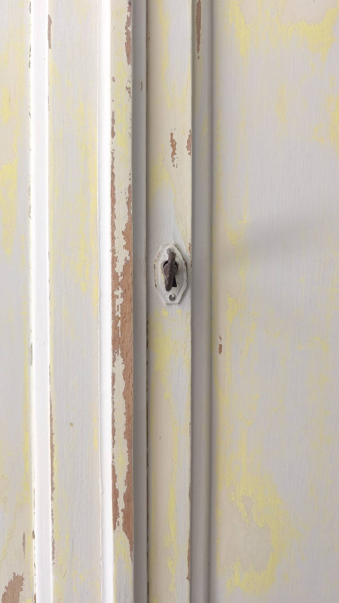Small antique wardrobe patinated in beige and yellow.