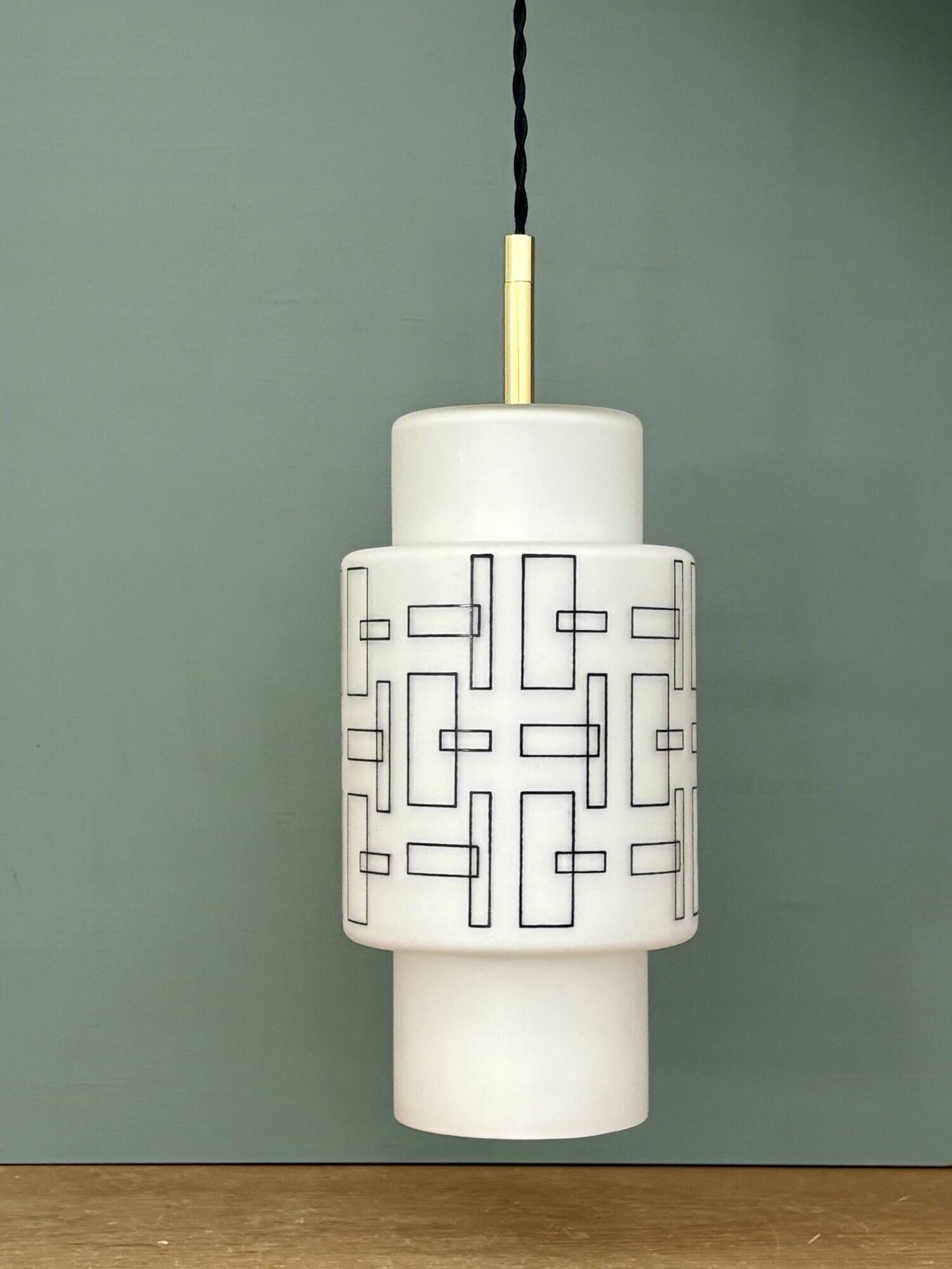 Vintage suspension globe in white opaline with black drawings.