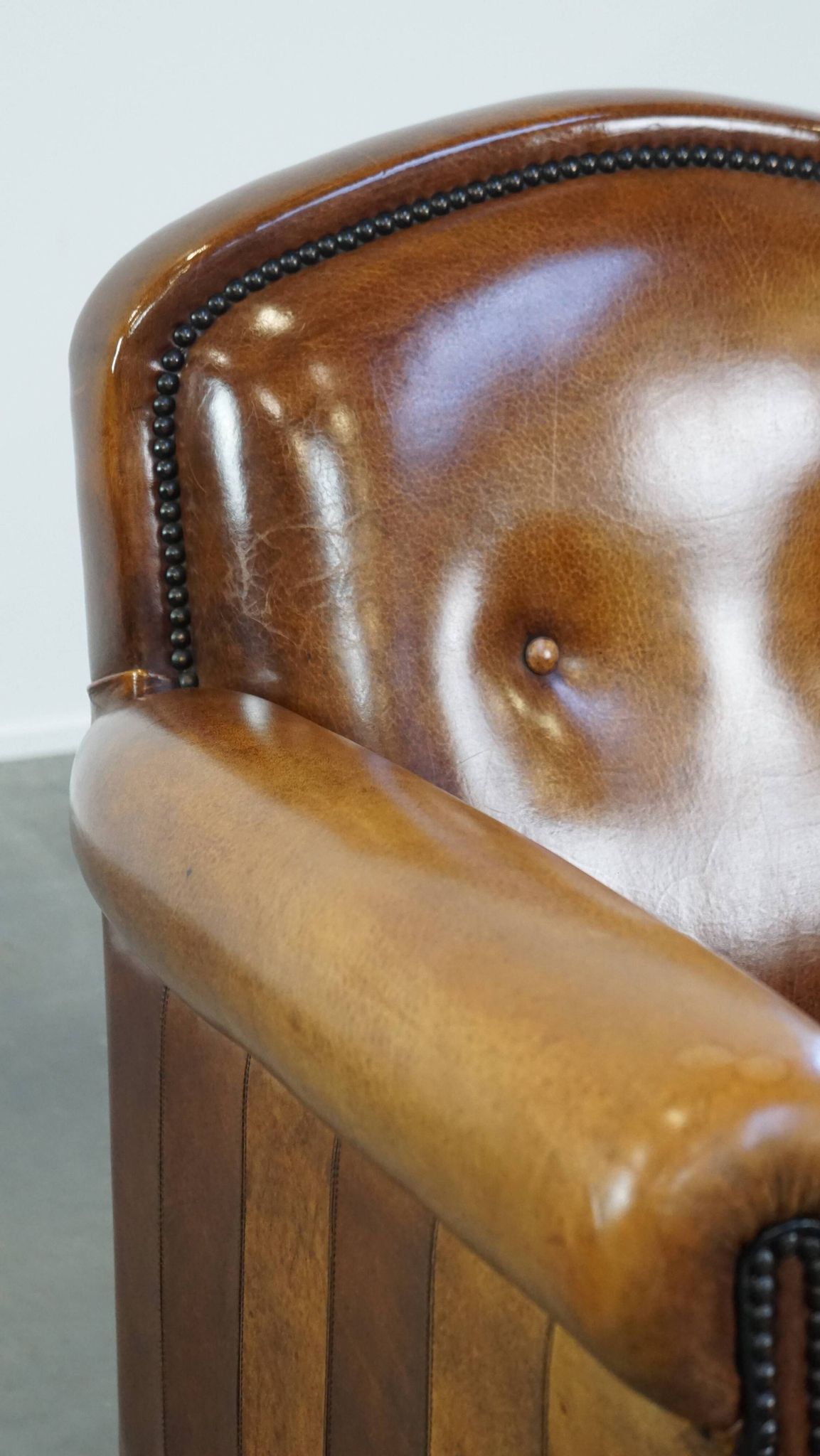Sheep leather design armchair finished with decorative nails and black piping
