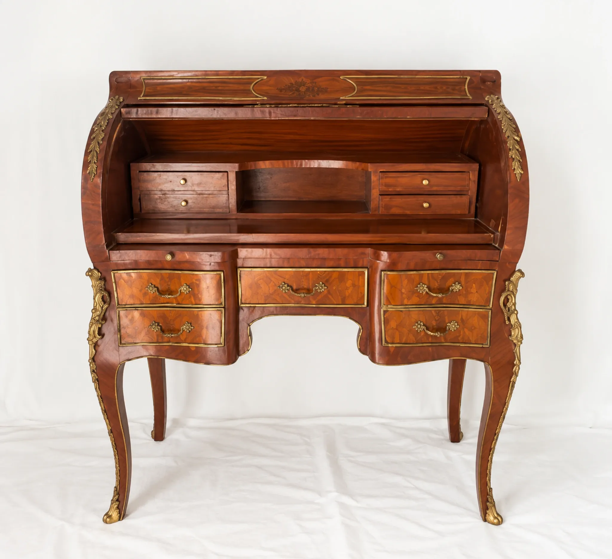 Louis XV cylinder desk with floral marquetry and gilded ornaments.