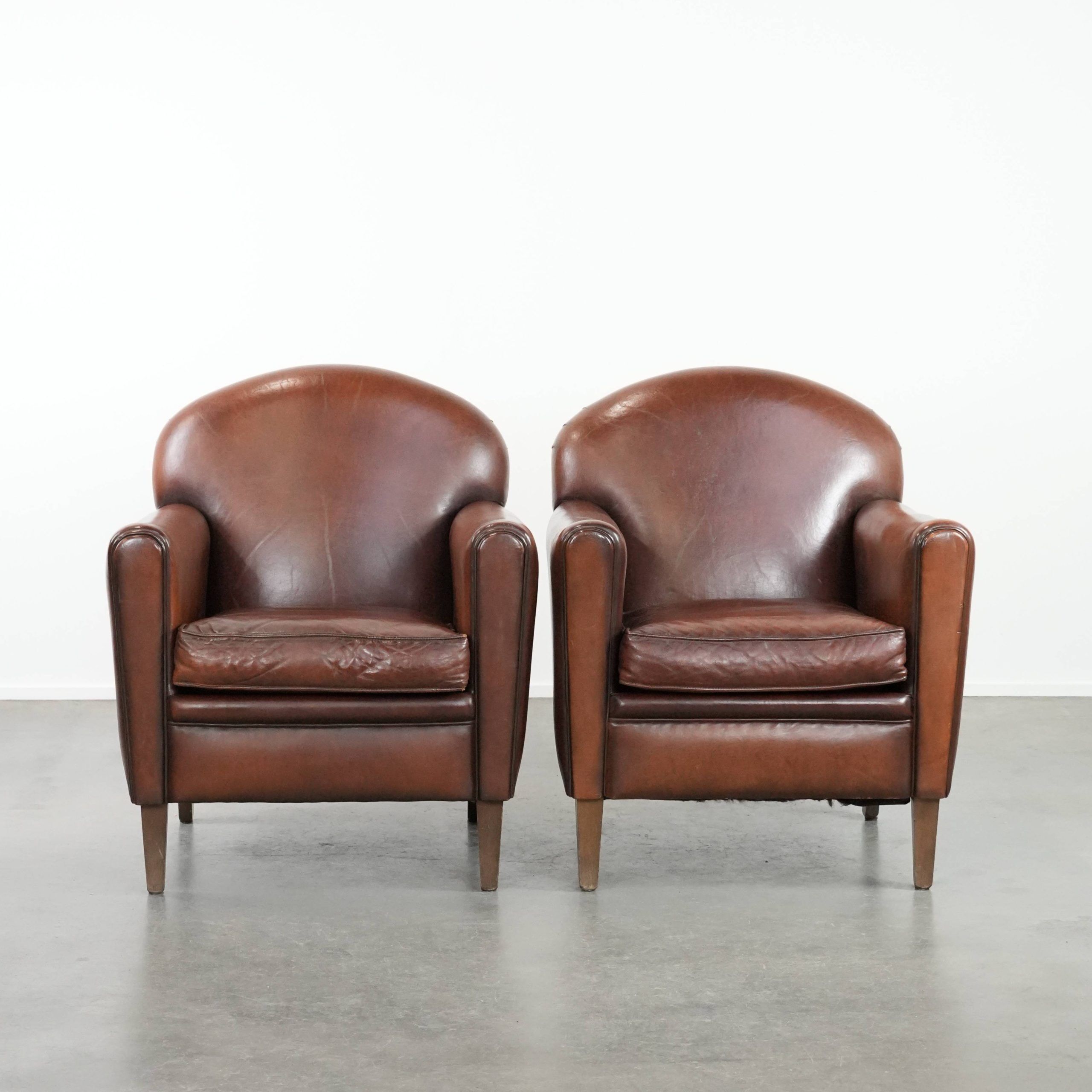 Ensemble de 2 fauteuils en peau de mouton au design art déco avec des couleurs chaudes.