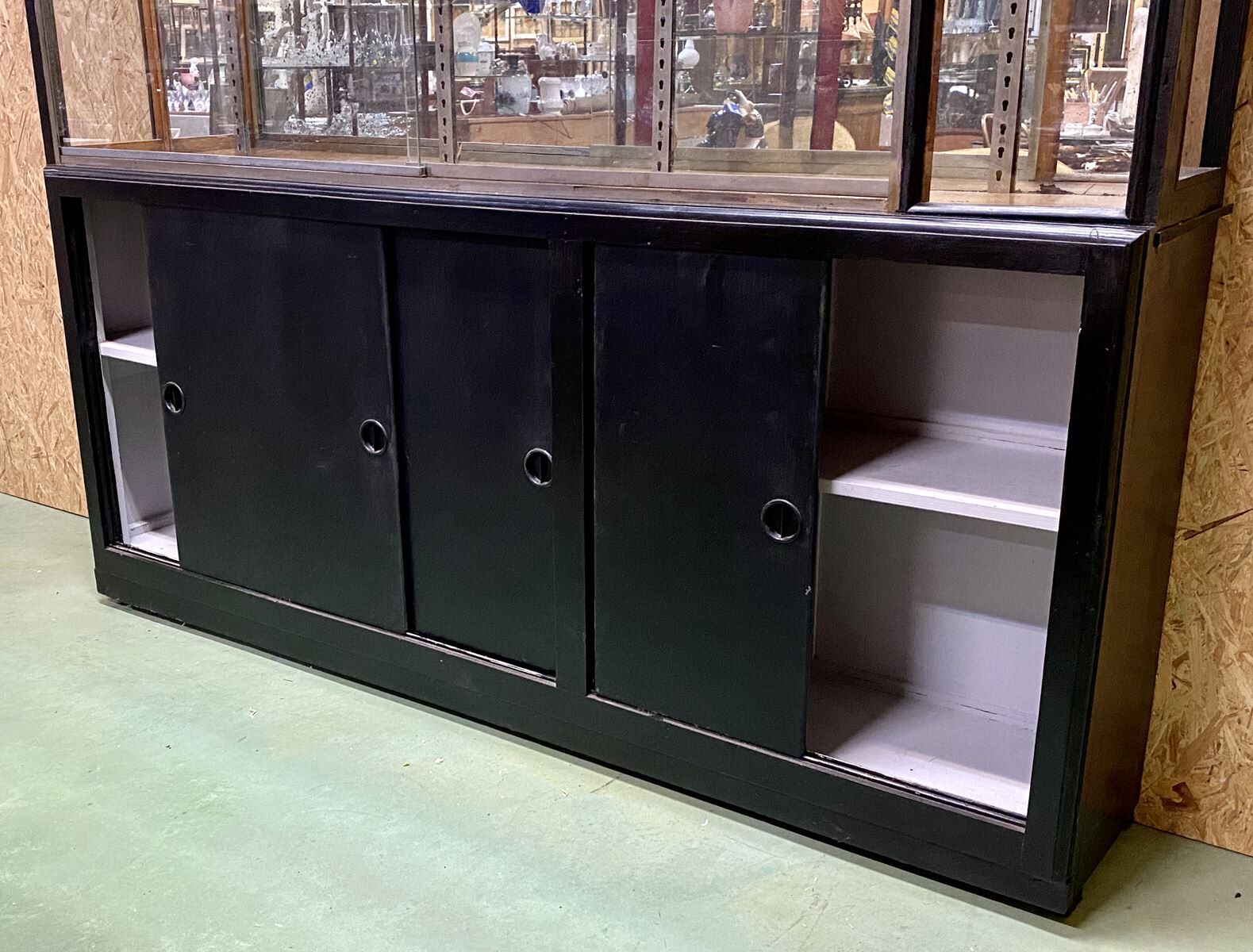 Store window with sliding doors in matte black patinated oak - 30s