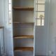 Shallow depth bookcase re-enchanted in pearl gray, wooden shelves.