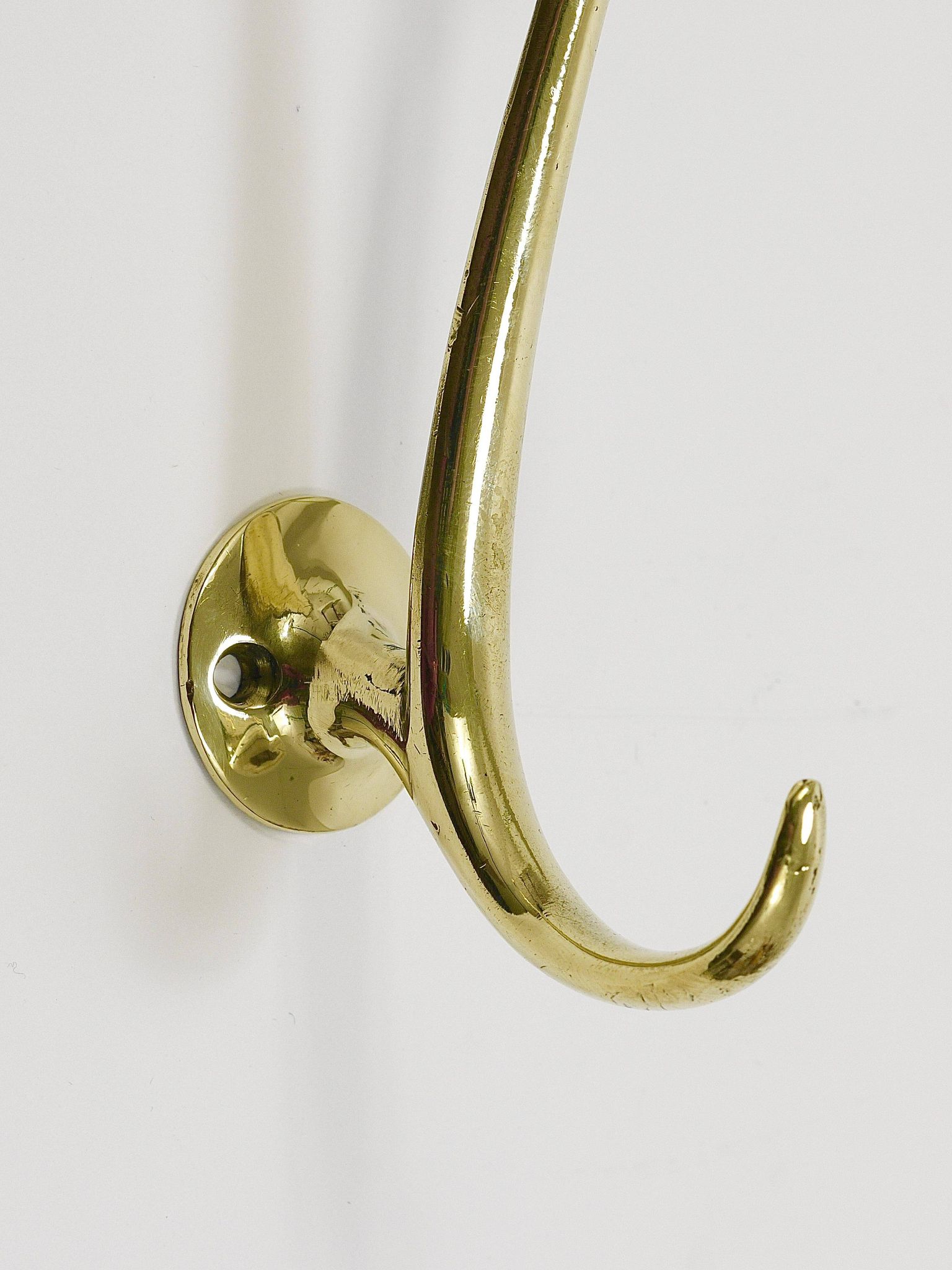 Two curved wall coat racks in brass by Franz Hagenauer, Vienna, mid-20th century, 1950s.