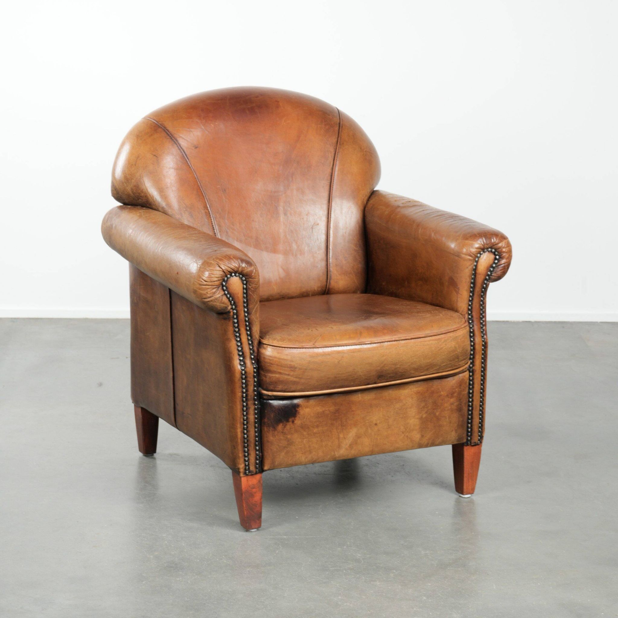 Sheepskin armchair with a beautiful vintage look and decorative nail finish