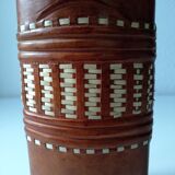 Vintage glass bottle covered with light brown leather and wicker