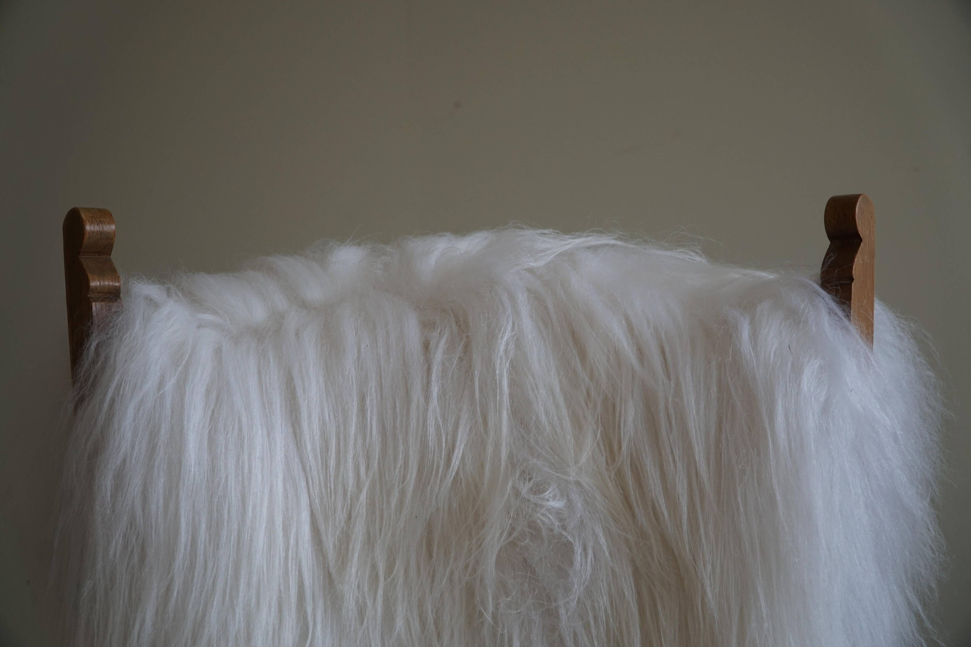 Pair of Scandinavian armchairs in oak and long-haired Icelandic sheepskin by Henning Kjærnulf, 1950.