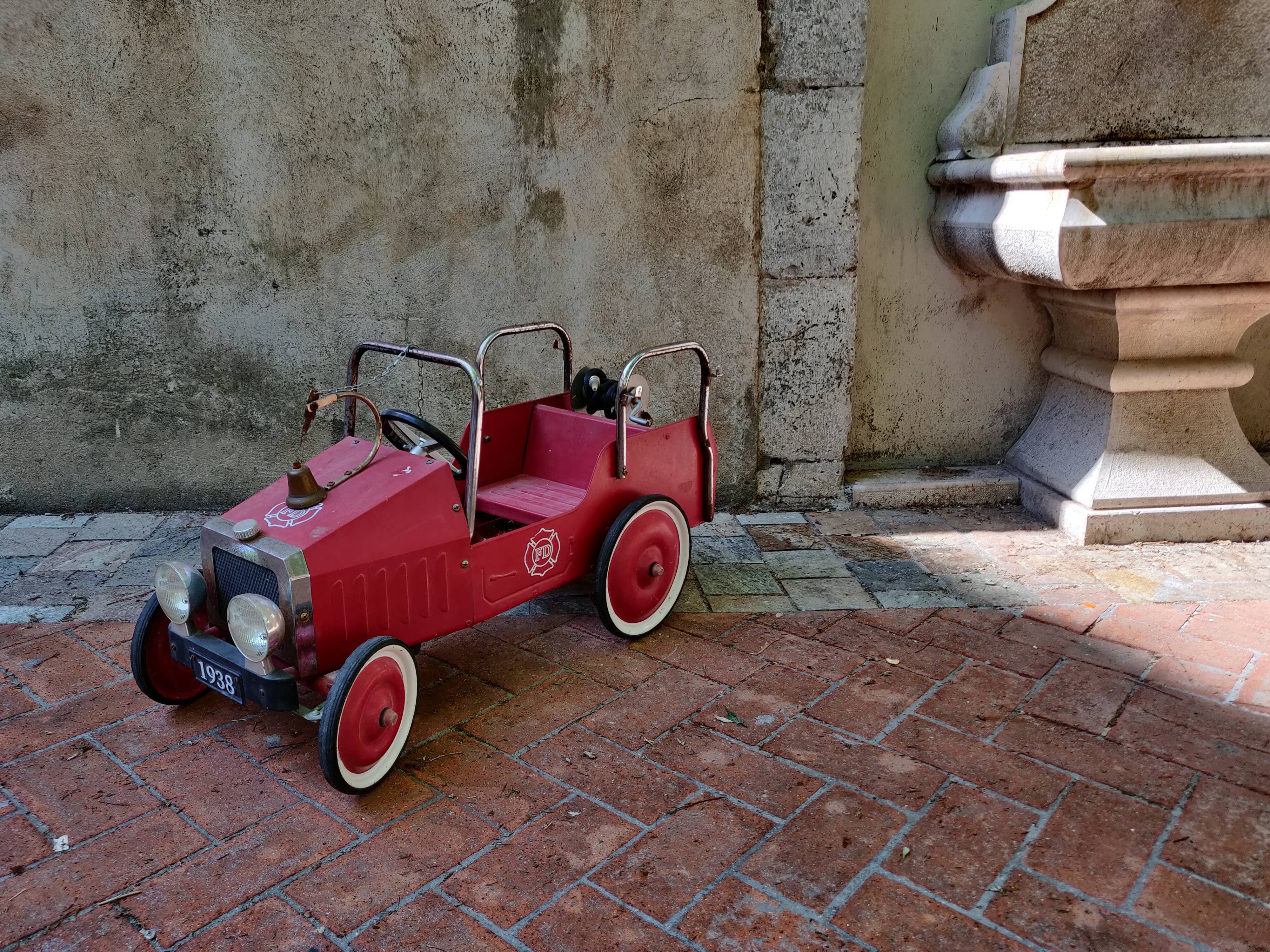 Old pedal car in tole fire truck