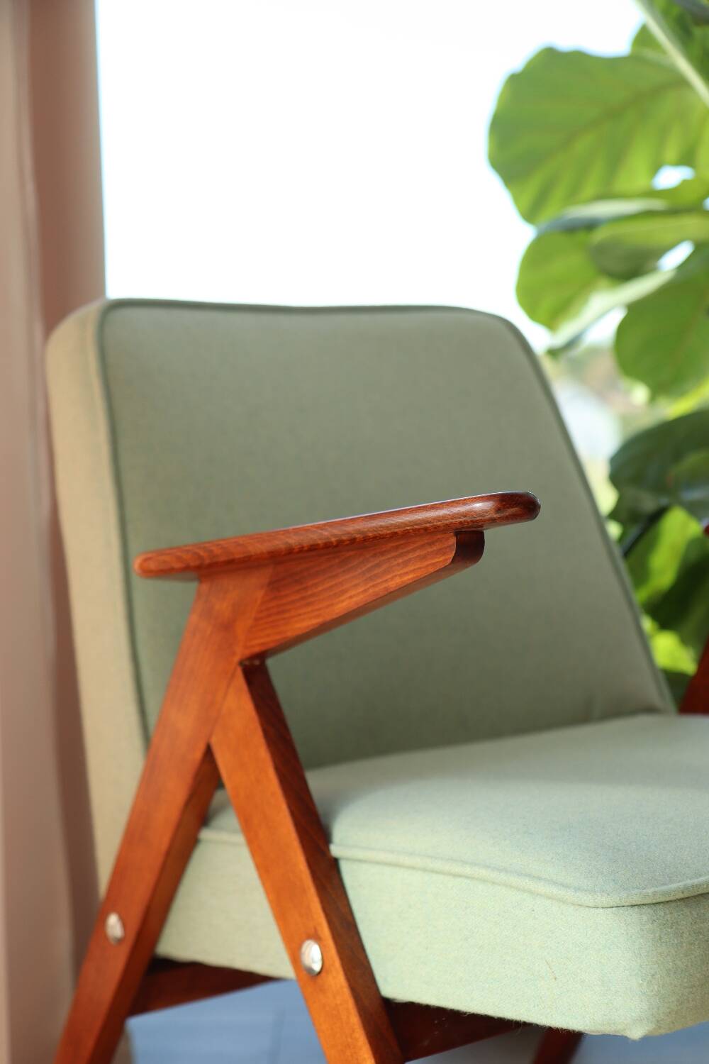 Vintage armchair in mint green wool, mid-century modern design.