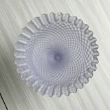 Purple glass pedestal bowl with wavy border and relief pattern.
