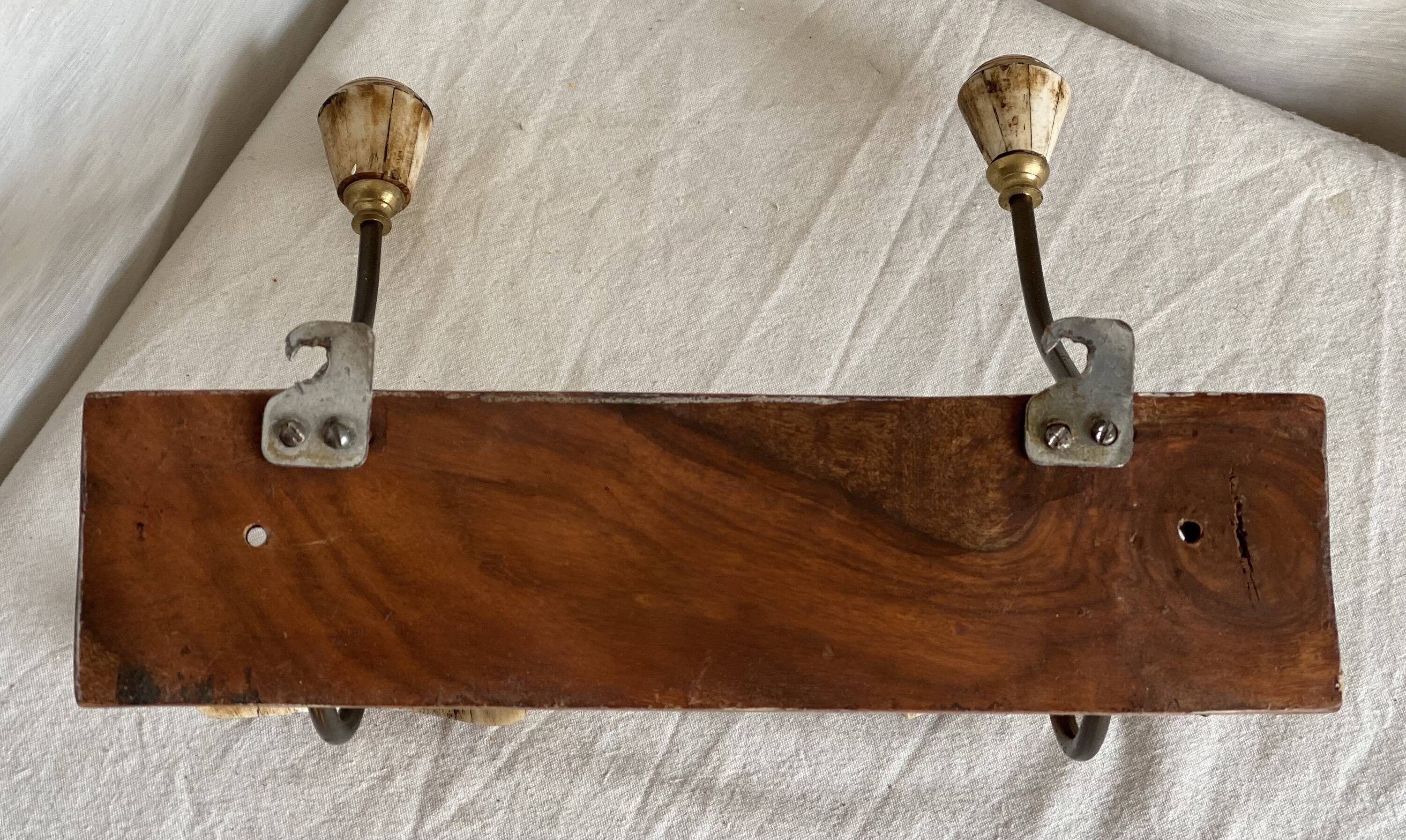 19th-century wall coat rack with 2 metal and horn hooks.